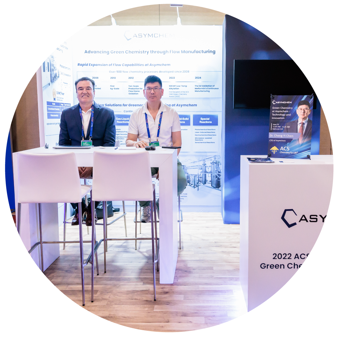 Image to two man working at an exhibitor booth at the conference.